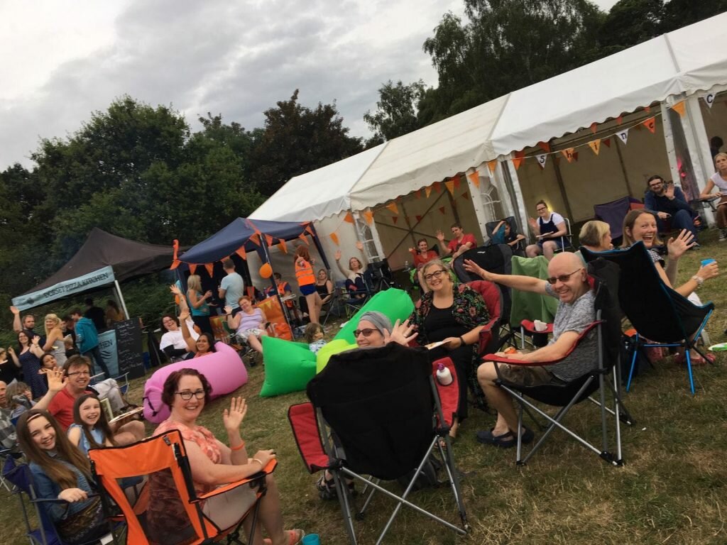 happy people at shine camp sitting outside the group marque